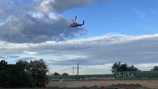 Frankfurt: Hubschrauber transportiert Oberleitungsmasten über Ginnheim